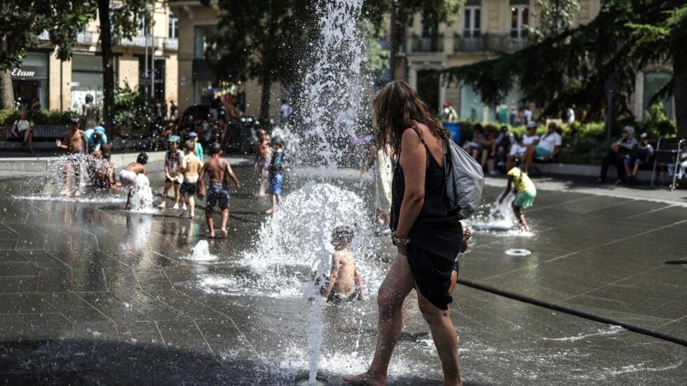 People cool off in a fountain in Toulouse, southwestern France on July 18, 2023. 
