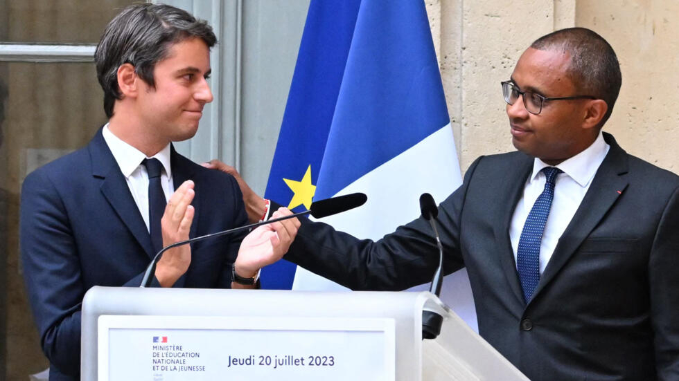 Former French Education and Youth Minister Pap Ndiaye (R) gestures next to newly appointed Education Minister Gabriel Attal (L) during a handover ceremony at the ministry of education in Paris on July 20, 2023.
