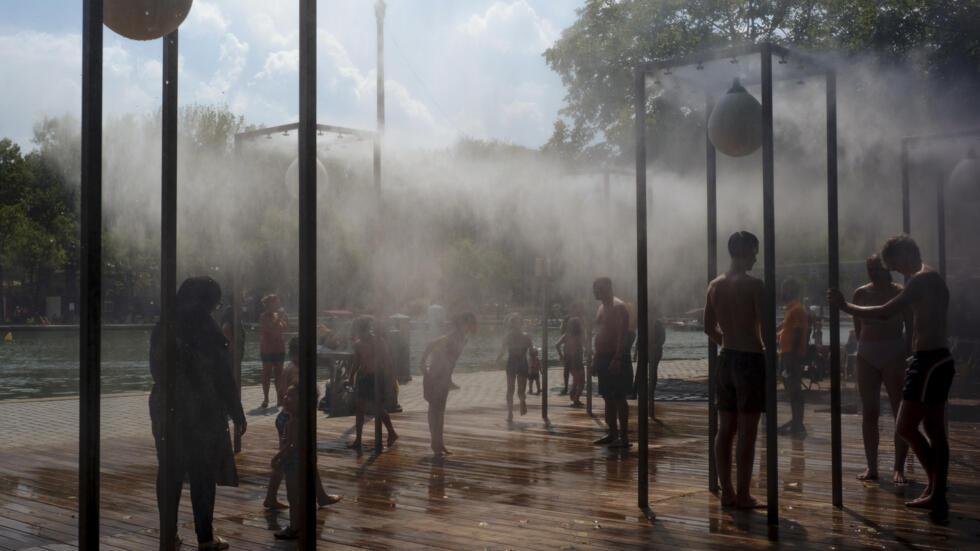 File photo: People cool off under a fountain along the Canal de l'Ourcq in Paris on Tuesday, August 11, 2020.