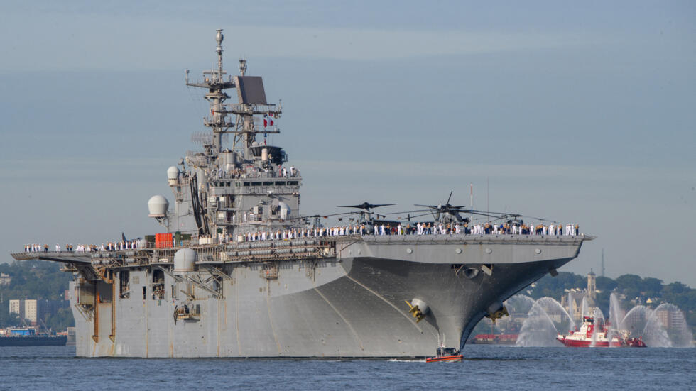 US armed forces personnel stand on the flight deck of the USS Bataan as the ship arrives for Fleet Week in New York Harbor on May 25, 2022.
